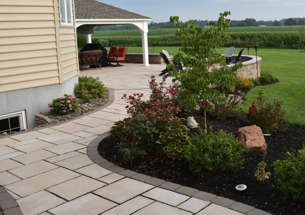paver walkway and patio with landscaping and big backyard