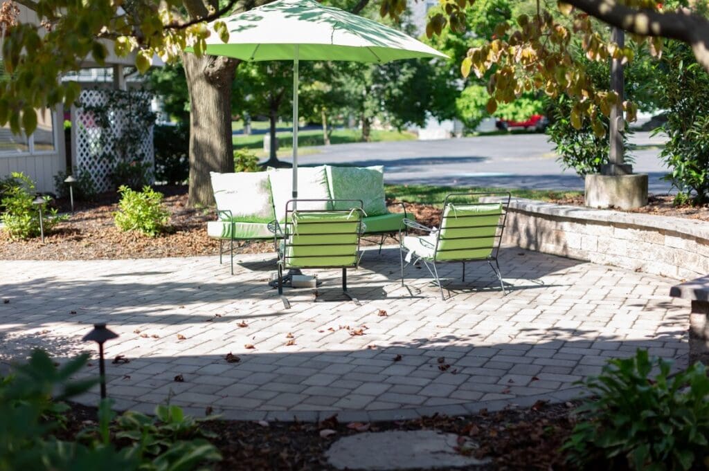 patio area with retaining wall and green lawn furniture