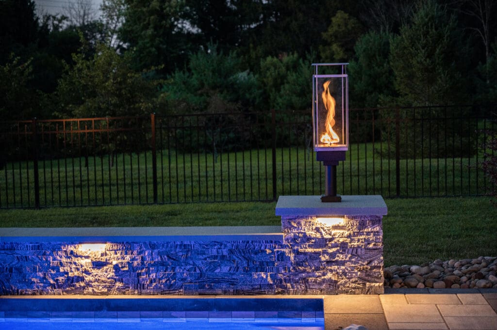 outdoor landscape lighting illuminating a patio and pool area