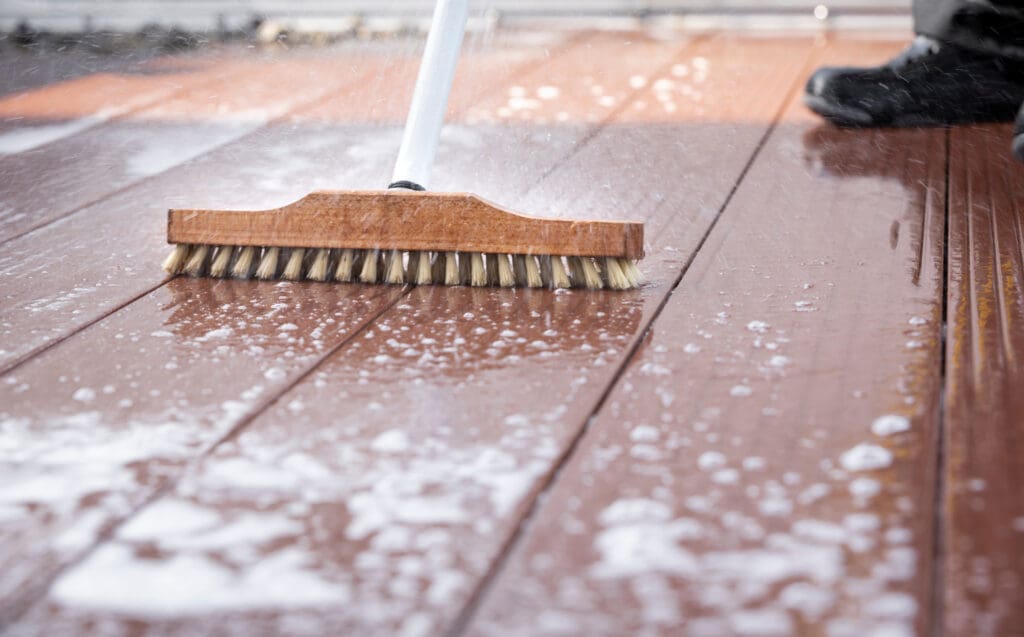 scrub brush with suds on wooden deck surface
