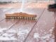 scrub brush with suds on wooden deck surface