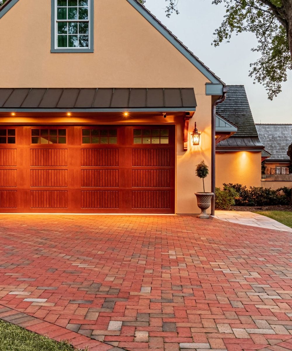 herringbone brick driveway with garage and beautiful lighting
