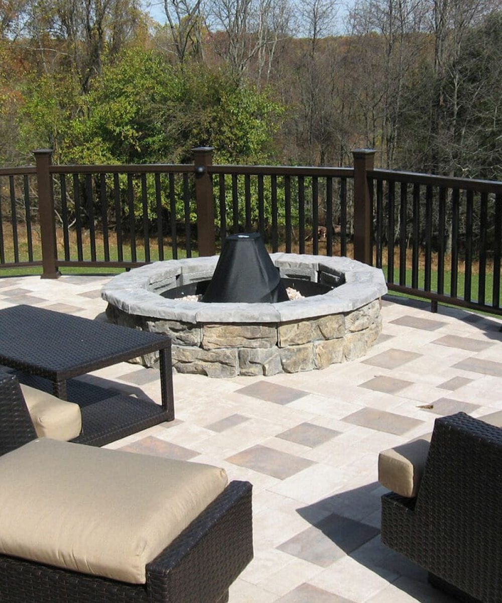 Stone deck with fire pit and outdoor seating area, showcasing durable stone surfaces and outdoor living space design.